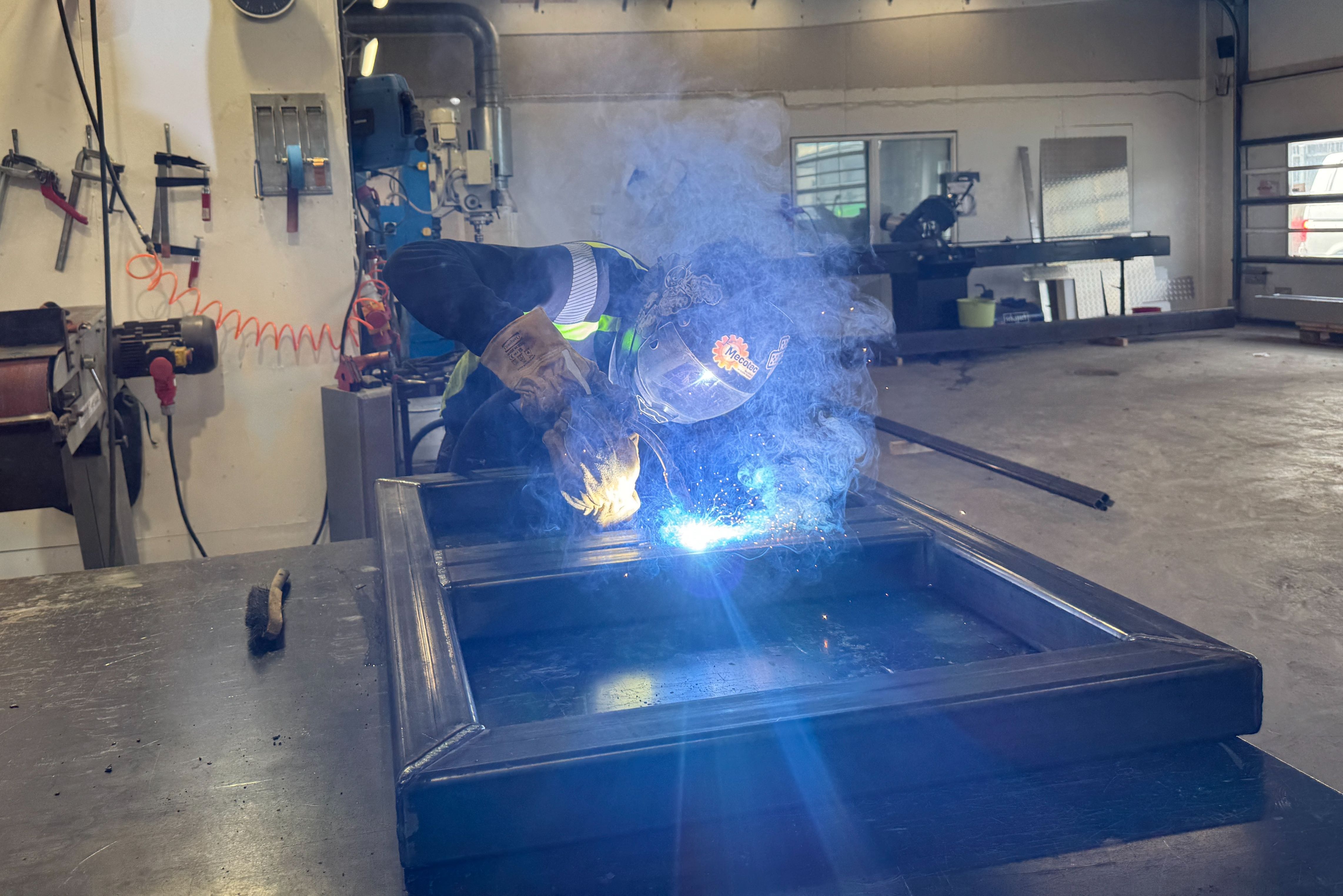 Svetsare i verkstad med gnistor